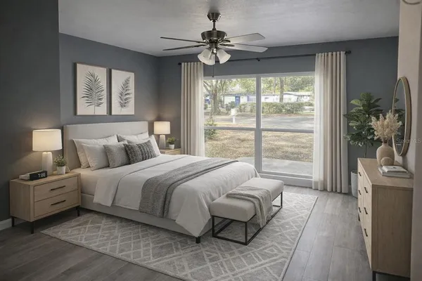 a bedroom with a large bed and a chandelier fan
