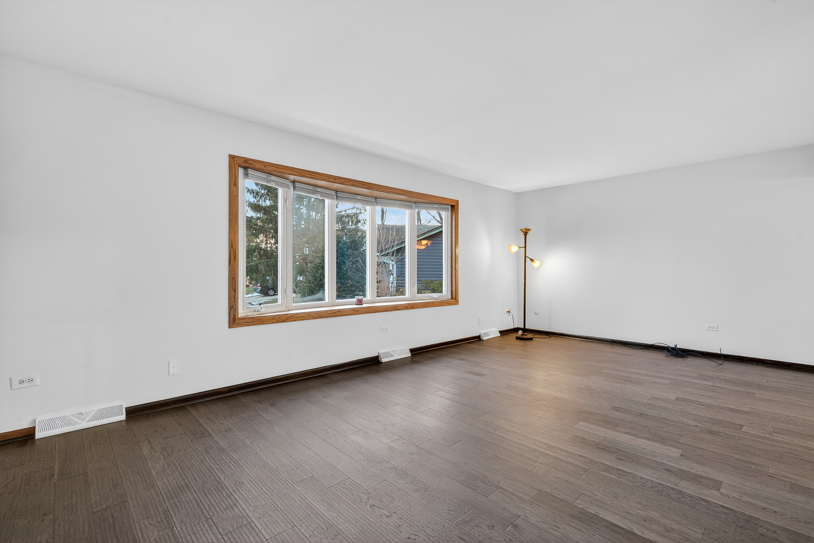 1790 Devonshire Court Elgin, IL 60123 - Photo 3 of 27 a view of an empty room with wooden floor and a window