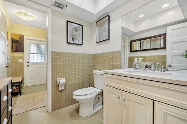 a bathroom with a granite countertop toilet sink and mirror
