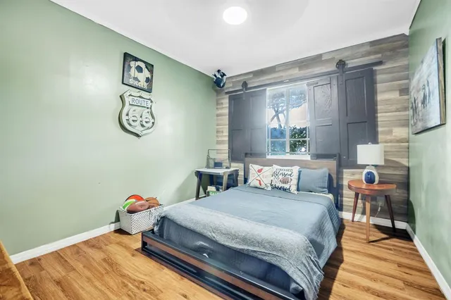 a bedroom with a bed and wooden floor