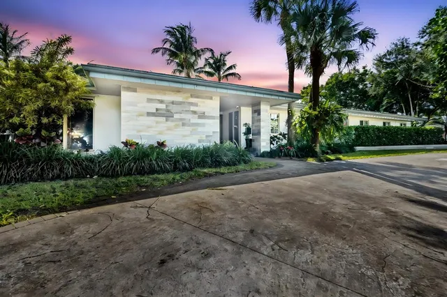 a living room with furniture a window and potted plants