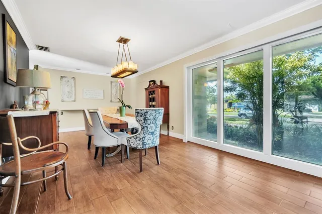a dining room with furniture a chandelier and wooden floor