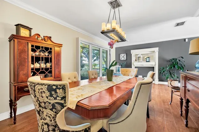 a dining room with furniture a chandelier and wooden floor