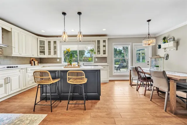 a dining room with furniture a chandelier and wooden floor