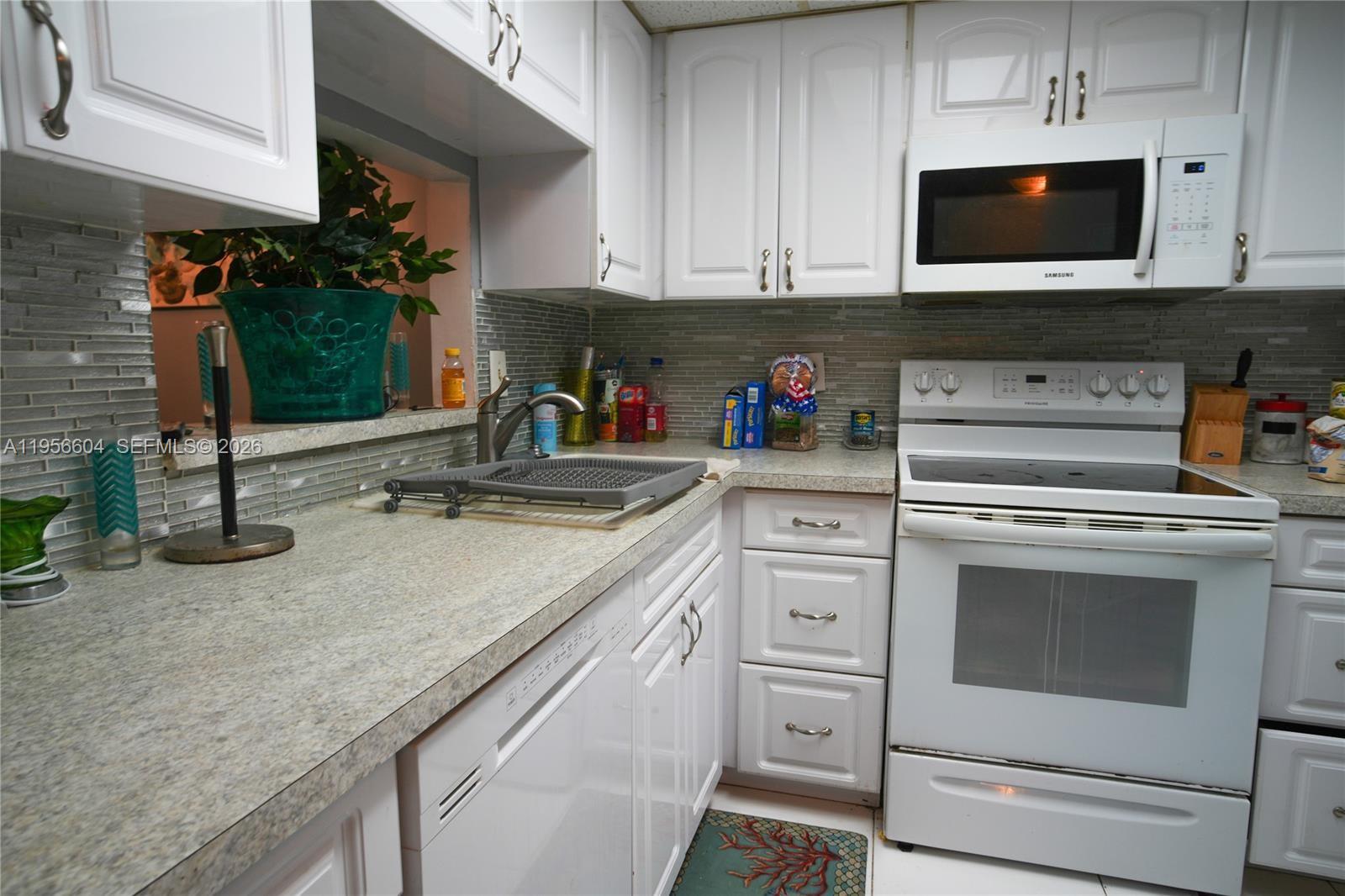 3774 Inverrary Boulevard, Unit 101P Lauderhill, FL 33319 - Photo 8 of 11 a kitchen with white cabinets and sink