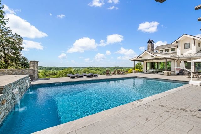 a view of a house with a swimming pool and a yard