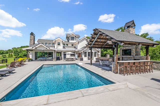 a view of a house with swimming pool and sitting area