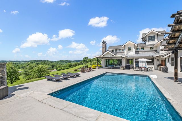 a view of a house with a swimming pool and a yard