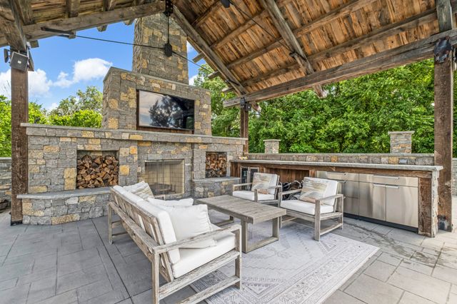 a view of a patio with couches table and chairs with wooden floor and fence