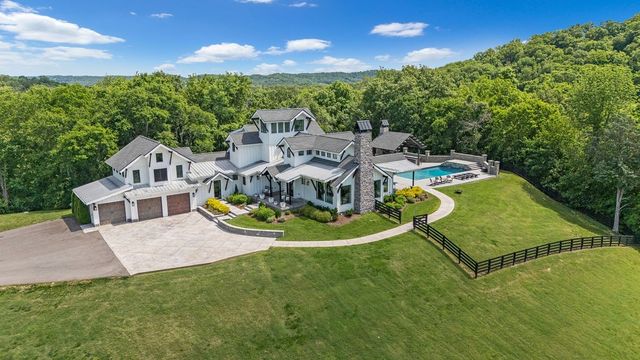 an aerial view of a house with swimming pool garden and patio