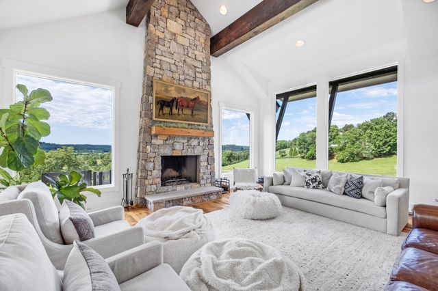 a living room with furniture fireplace and a large window