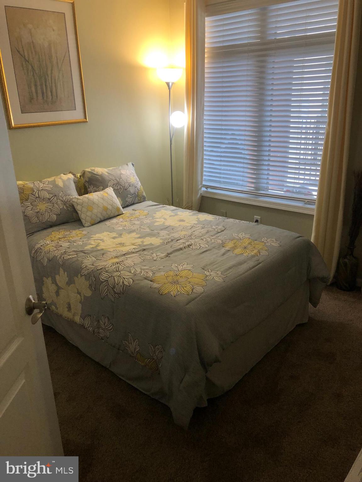 239 Carson Terrace, Unit 239 Huntingdon Valley, PA 19006 - Photo 14 of 19 a bed sitting in a bedroom next to a window