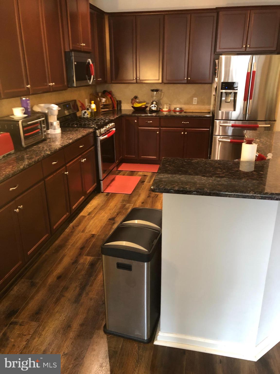 239 Carson Terrace, Unit 239 Huntingdon Valley, PA 19006 - Photo 3 of 19 a kitchen with granite countertop a sink a stove and wooden cabinets