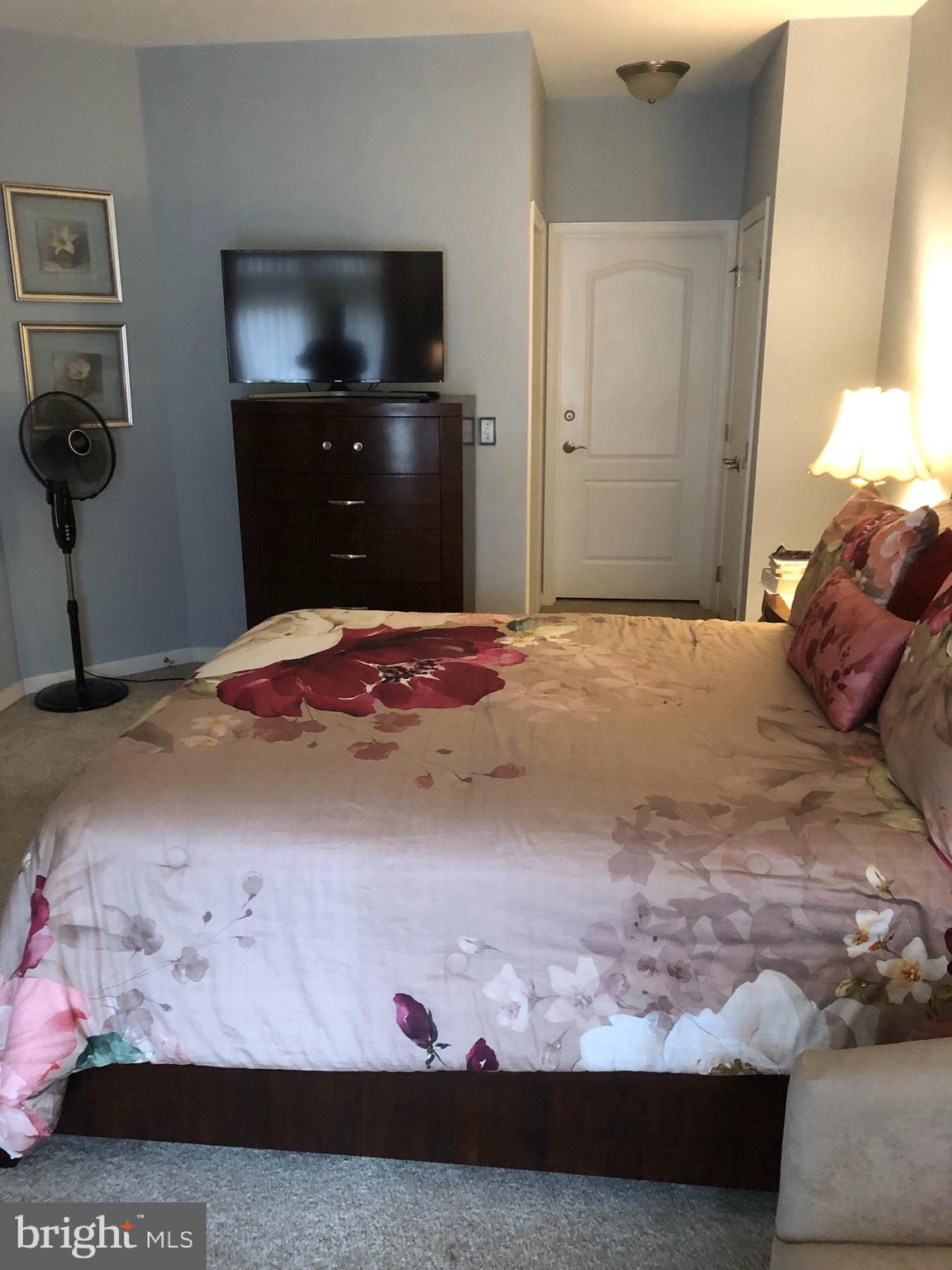 239 Carson Terrace, Unit 239 Huntingdon Valley, PA 19006 - Photo 8 of 19 a bedroom with a bed and a view of kitchen