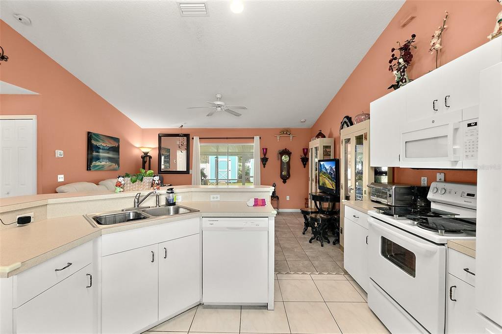 8 Karat Path Palm Coast, FL 32164 - Photo 16 of 37 a kitchen with stainless steel appliances kitchen island granite countertop a sink and cabinets