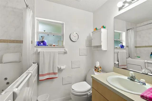 a bathroom with a sink toilet vanity and tub