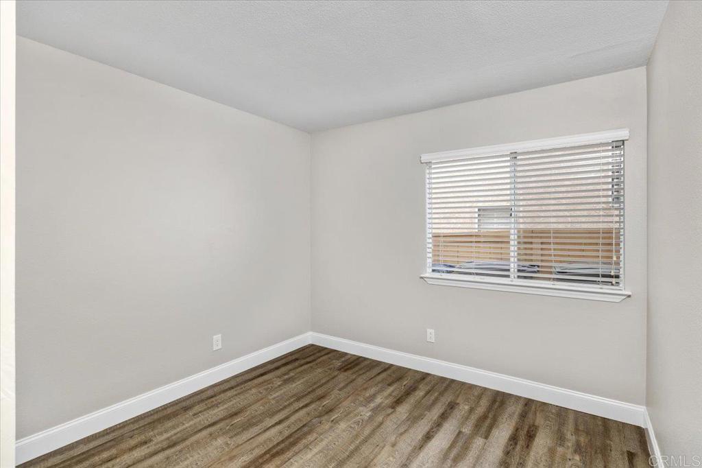 1533 Promontory Ridge Way Vista, CA 92081 - Photo 12 of 26 a view of an empty room with wooden floor and a window