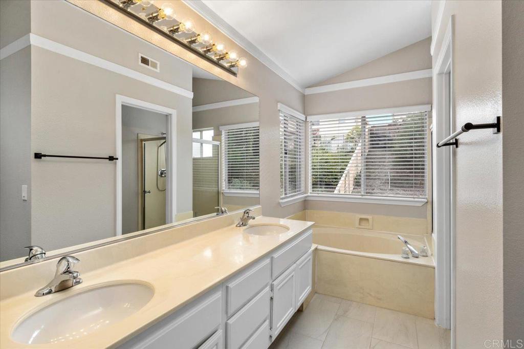 1533 Promontory Ridge Way Vista, CA 92081 - Photo 15 of 26 a bathroom with a granite countertop tub sink and mirror