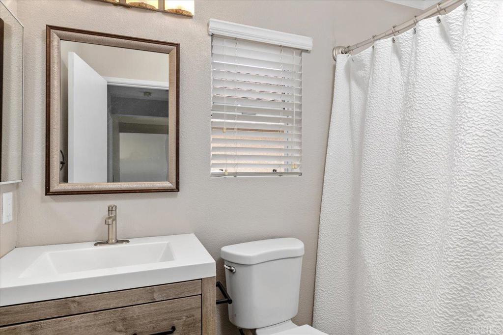 1533 Promontory Ridge Way Vista, CA 92081 - Photo 17 of 26 a bathroom with a sink a toilet and a mirror