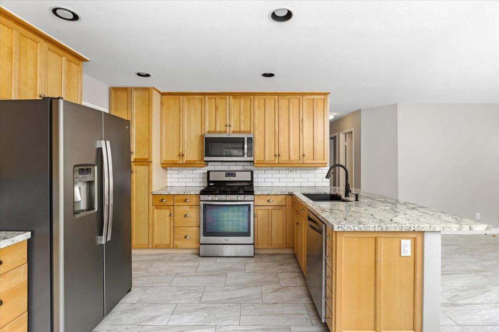 1533 Promontory Ridge Way Vista, CA 92081 - Photo 10 of 26 a kitchen with stainless steel appliances granite countertop a refrigerator stove and oven