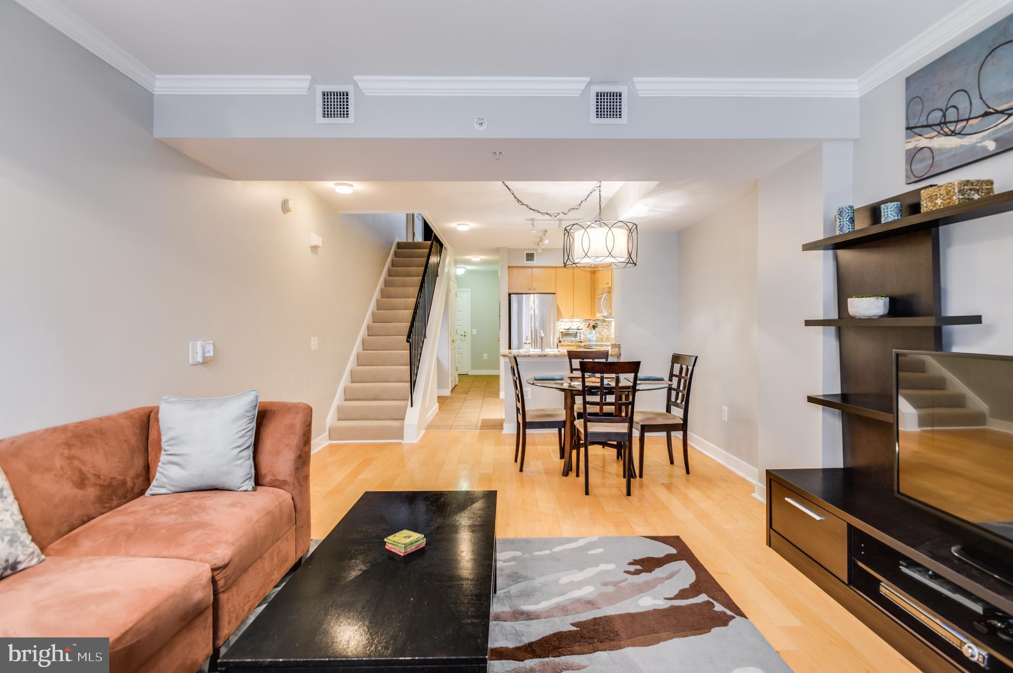 616 E Street Northwest, Unit 446 Washington, DC 20004 - Photo 14 of 66 a living room with furniture and a dining table with wooden floor