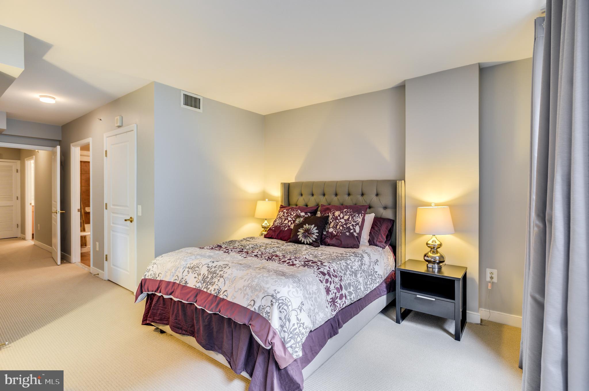 616 E Street Northwest, Unit 446 Washington, DC 20004 - Photo 17 of 66 a bedroom with a bed and a lamp