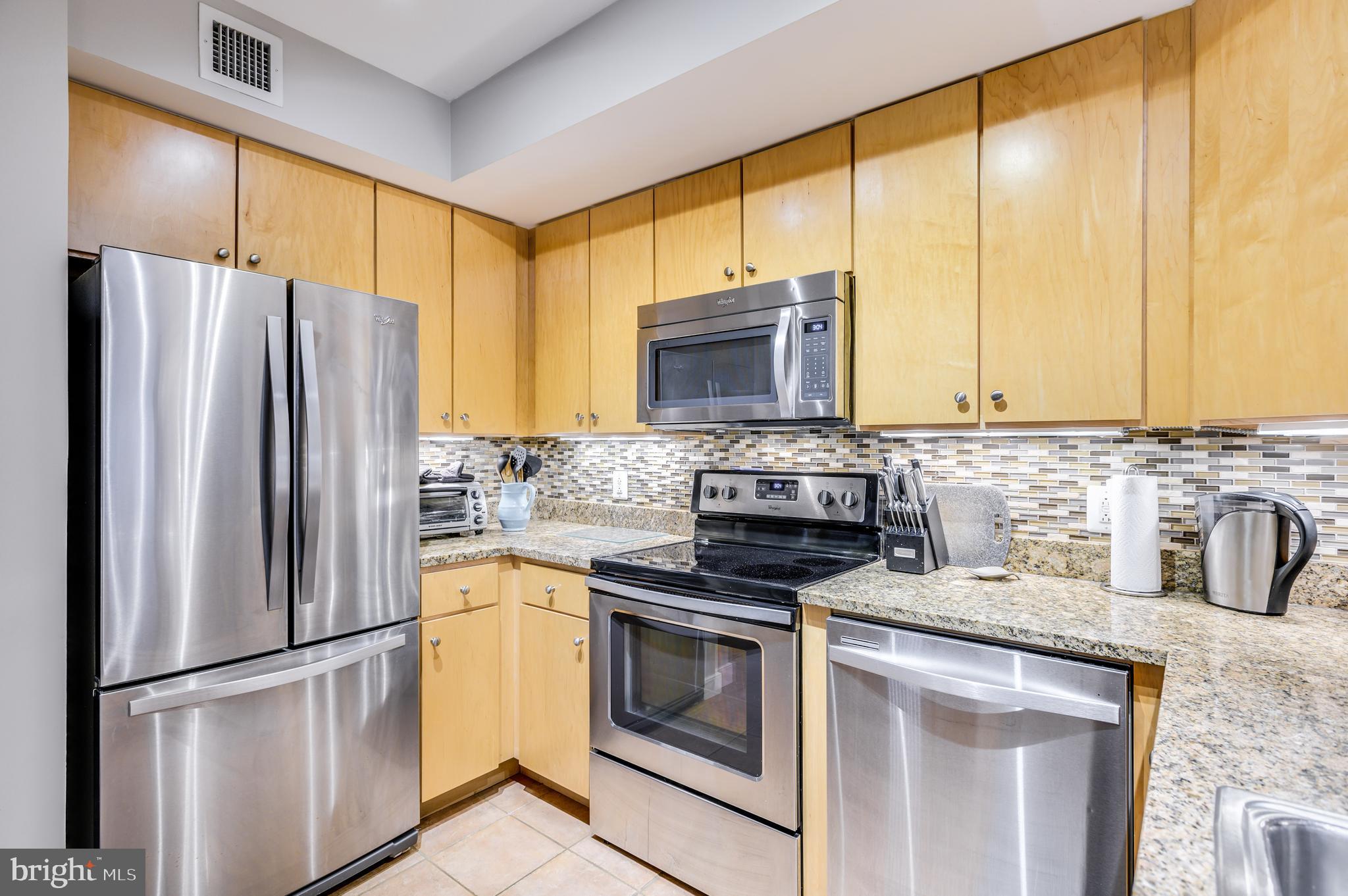 616 E Street Northwest, Unit 446 Washington, DC 20004 - Photo 5 of 66 a kitchen with stainless steel appliances granite countertop a refrigerator stove and microwave