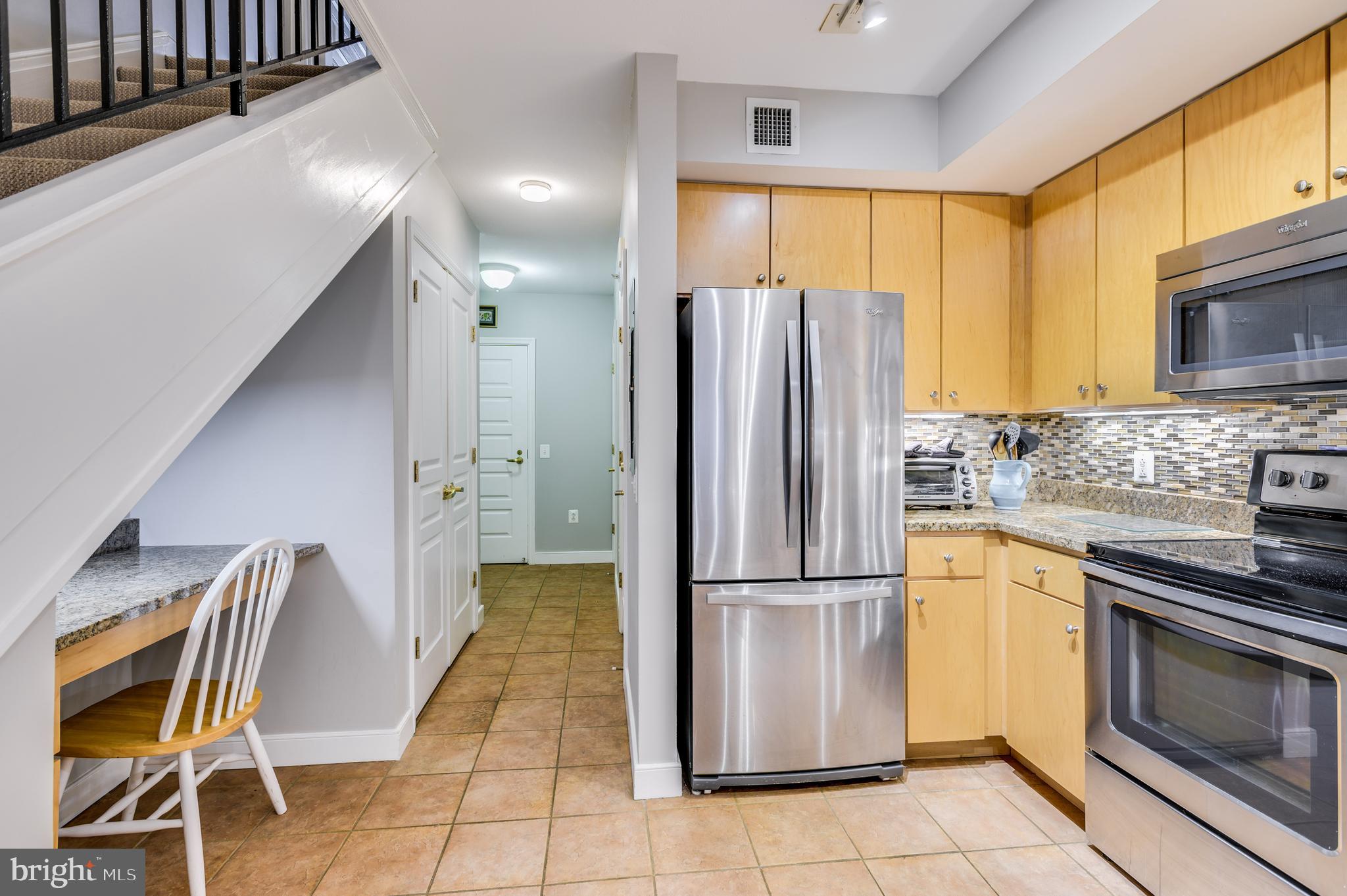 616 E Street Northwest, Unit 446 Washington, DC 20004 - Photo 6 of 66 a kitchen with stainless steel appliances granite countertop a refrigerator a stove and a sink with granite countertops