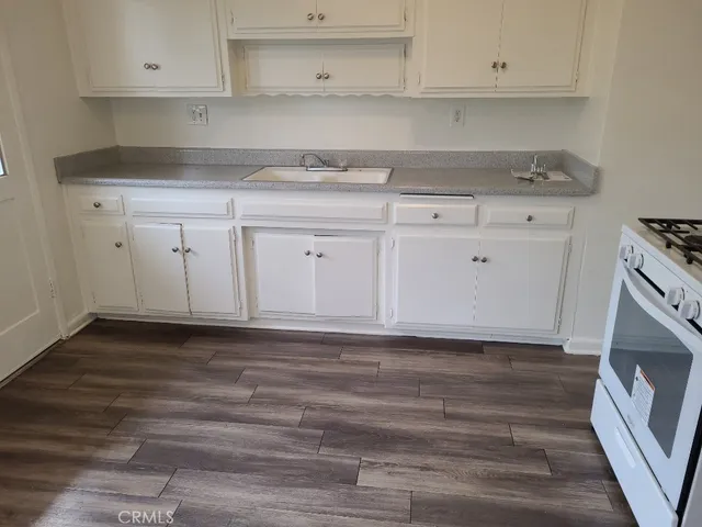 a kitchen with granite countertop white cabinets and a stove