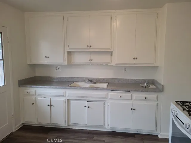 a kitchen with granite countertop white cabinets and a stove