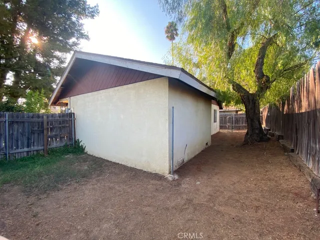a view of a house with a tree and wooden fence