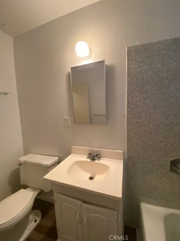 a bathroom with a sink a toilet and mirror