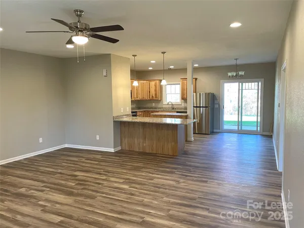 a view of kitchen with granite countertop cabinets and refrigerator