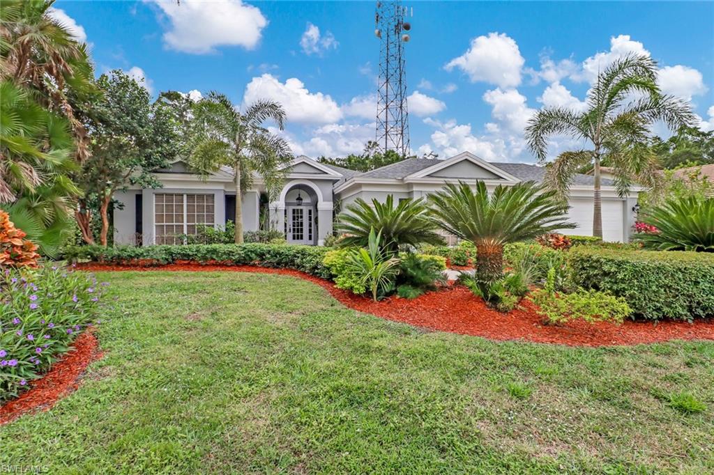a front view of a house with a yard and fountain in middle