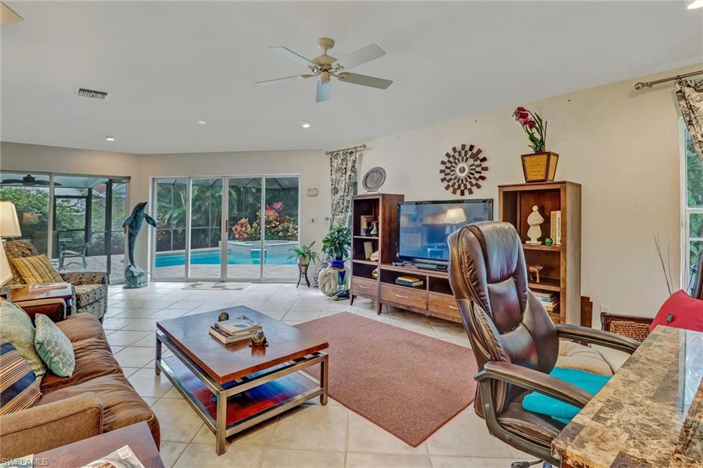 6917 Mill Run Road Naples, FL 34109 - Photo 11 of 29 a living room with furniture gym equipment and a rug