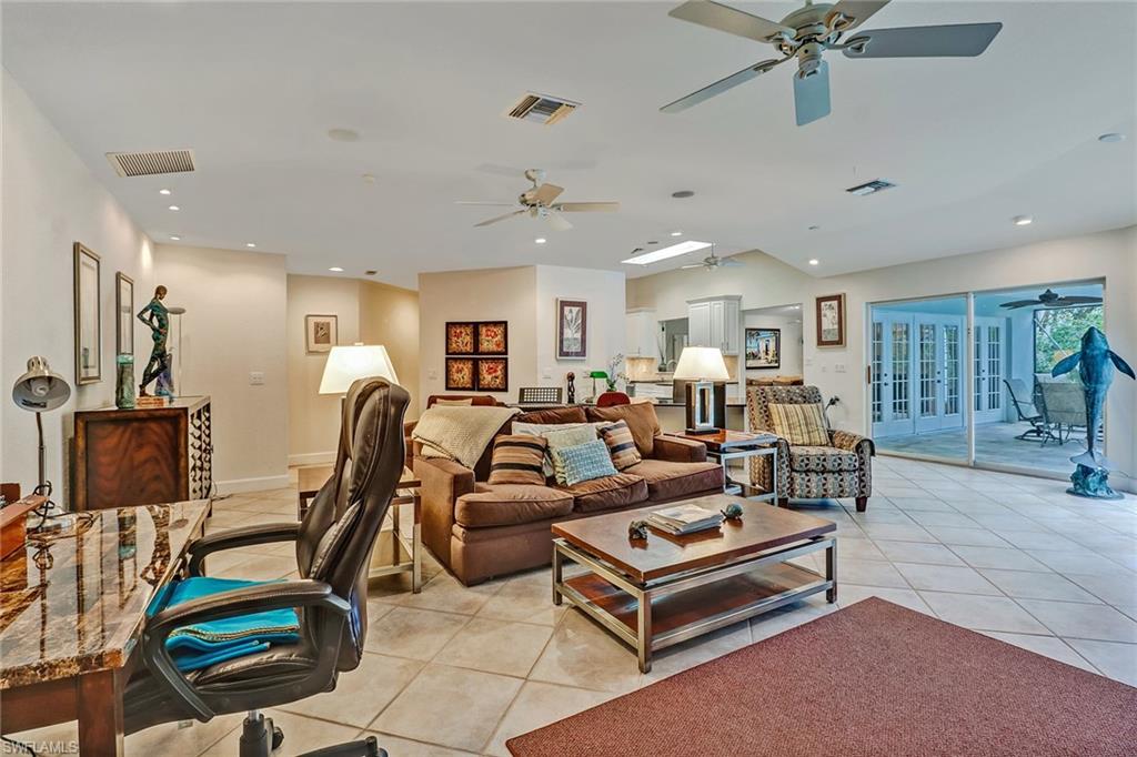 6917 Mill Run Road Naples, FL 34109 - Photo 12 of 29 a living room with furniture gym equipment and a flat screen tv