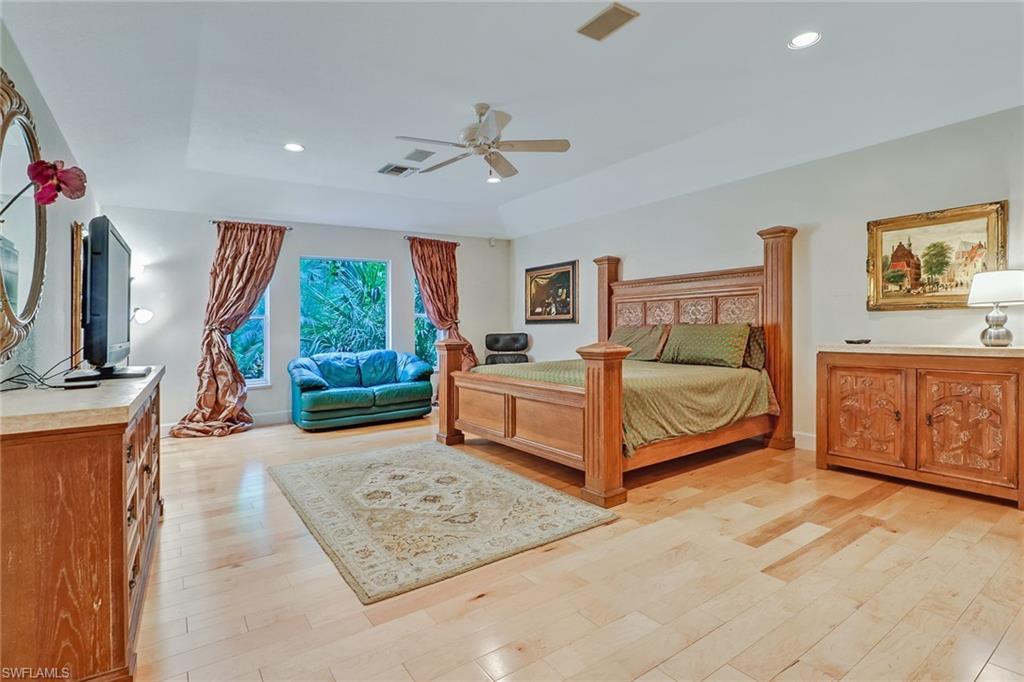6917 Mill Run Road Naples, FL 34109 - Photo 21 of 29 a spacious bedroom with a bed a window and dresser