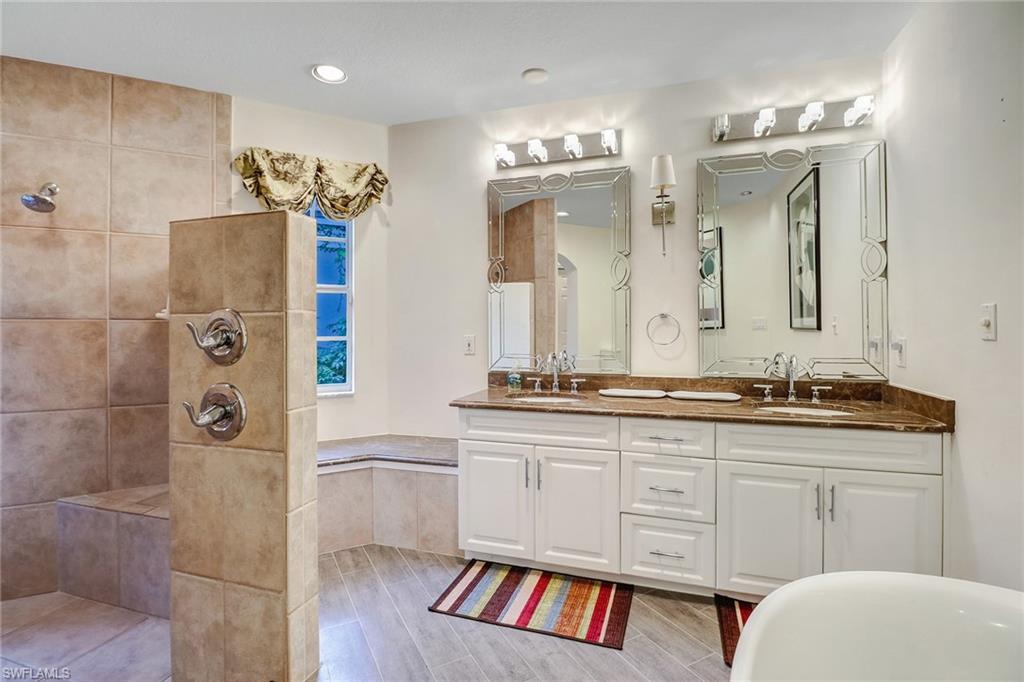 6917 Mill Run Road Naples, FL 34109 - Photo 25 of 29 a spacious bathroom with a granite countertop sink a toilet a mirror and shower