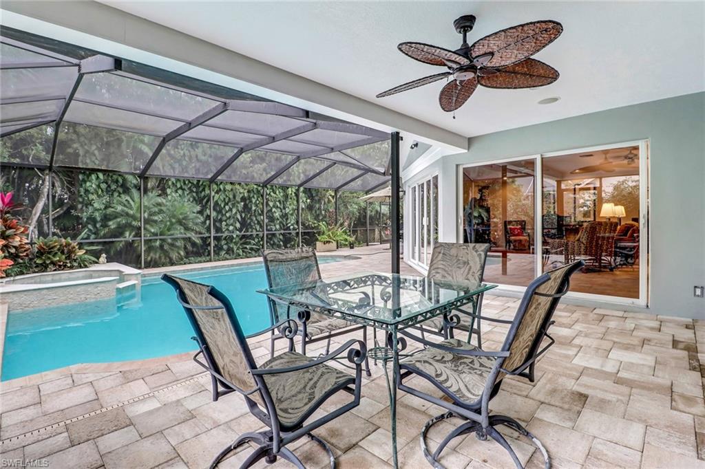 6917 Mill Run Road Naples, FL 34109 - Photo 27 of 29 a view of a dining table and chairs under an umbrella