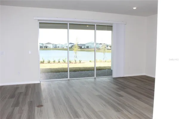 a large kitchen with stainless steel appliances granite countertop a large counter top and a wooden floor