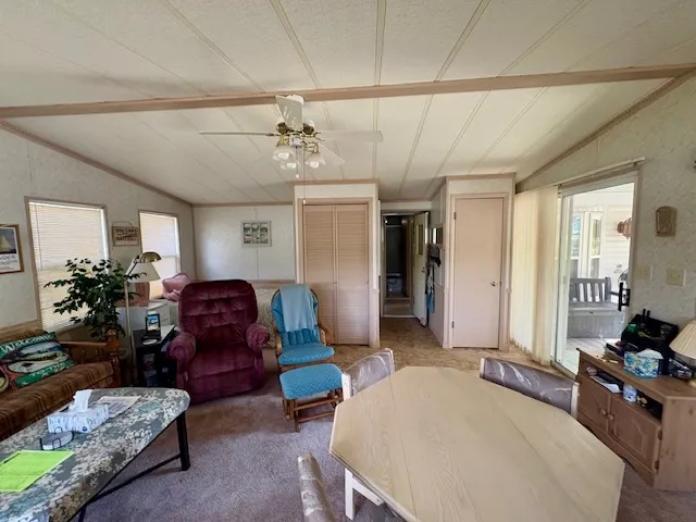 a living room with furniture a chandelier and a dining table