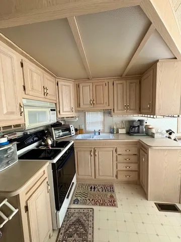 a kitchen with granite countertop a sink stove a refrigerator and cabinets