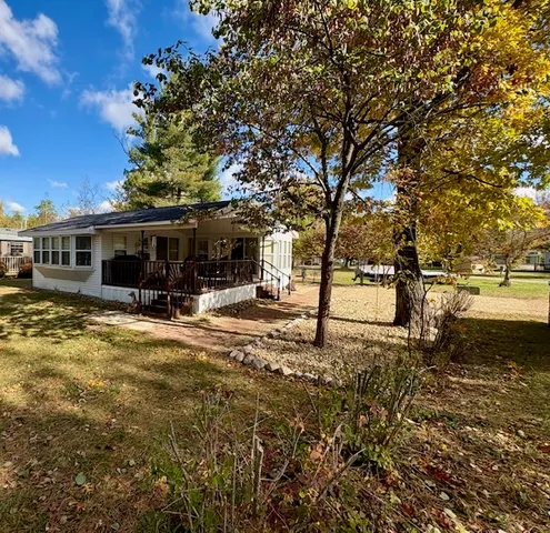 a view of a house with backyard and tree