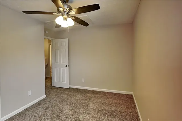 an empty room with a fan and a fan