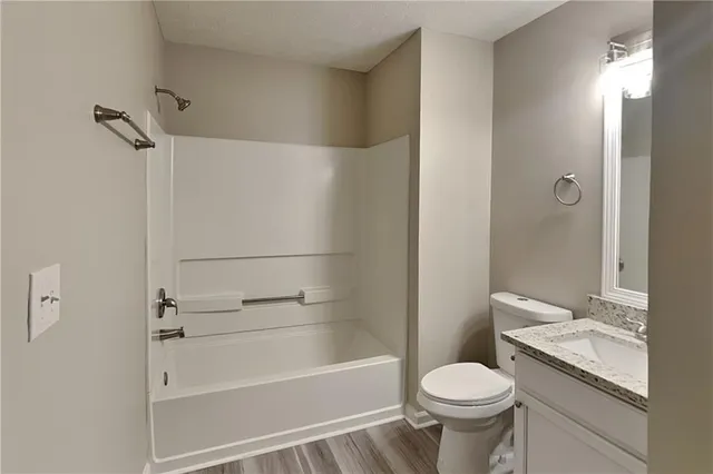 a bathroom with a granite countertop toilet sink and shower