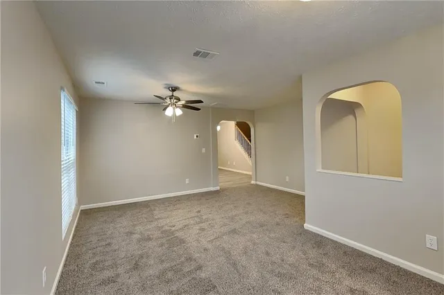 an empty room with a chandelier fan