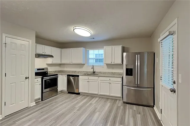 a kitchen with stainless steel appliances a refrigerator sink and stove top oven