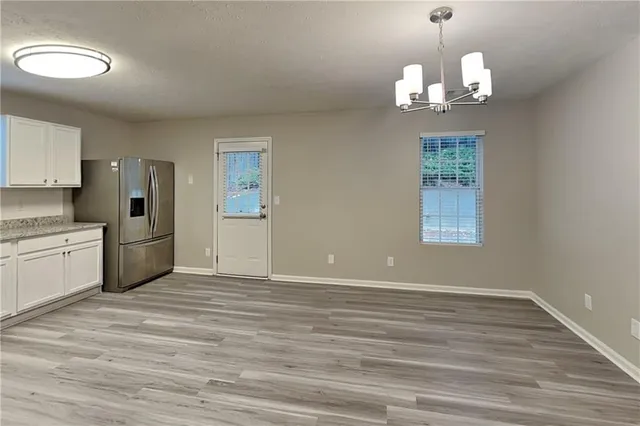 a view of a kitchen with a sink dishwasher a stove and dishwasher with wooden floor
