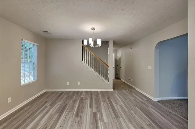 wooden floor in a hall with an entryway and a window