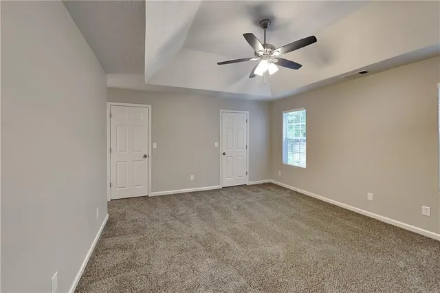 an empty room with window and ceiling fan